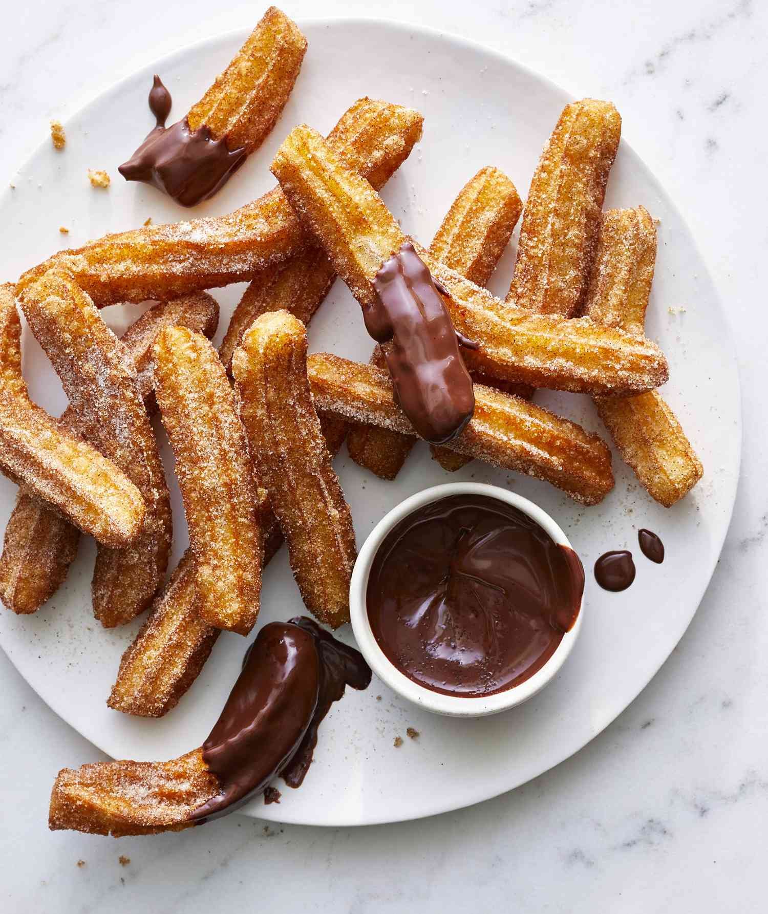 Churros con salsa de chocolate en un plato.