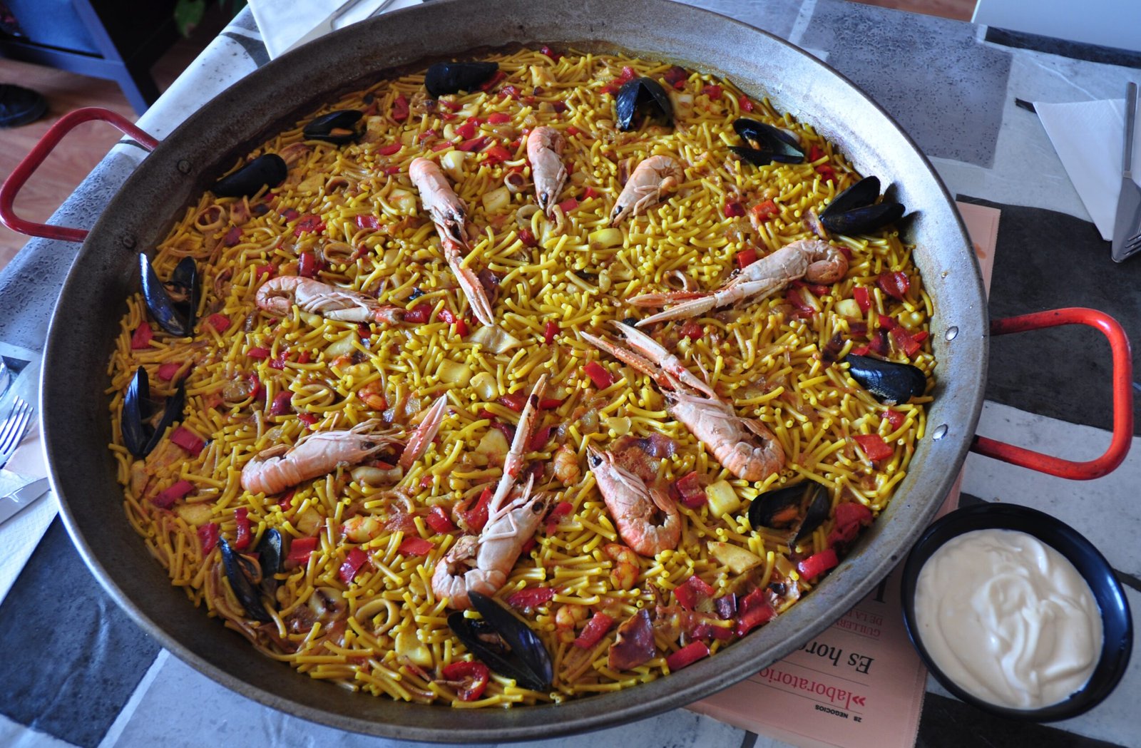 Una gran cacerola de fideuá sobre una mesa.